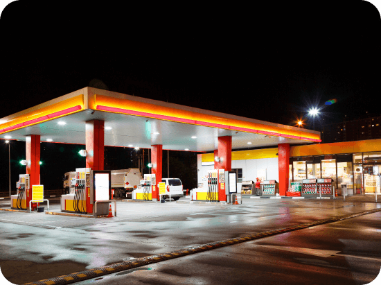 A forecourt and convenience store lit up at night