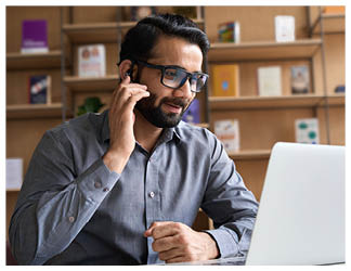 Indian business man professional employee, remote consultant, customer service support manager wearing headset talking at virtual meeting consulting client on video call at home office call center 