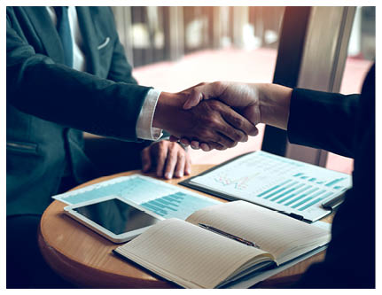 Two businessmen are talking and making deals on business operations and agreeing by shaking hands in the office 